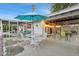 Charming back patio with white mid-century modern furniture, teal umbrella, and covered outdoor seating area at 421 N Evergreen St, Chandler, AZ 85225
