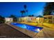 Stunning backyard pool with clear blue water, surrounded by a patio, palm trees, and a covered outdoor seating area at 421 N Evergreen St, Chandler, AZ 85225