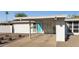 An eye-level view shows a well-kept home featuring a covered carport, xeriscaped yard and eye-catching blue door at 421 N Evergreen St, Chandler, AZ 85225