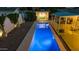 A long, sparkling pool is beautifully illuminated at night, lined with an outdoor lounge and covered sitting area at 421 N Evergreen St, Chandler, AZ 85225