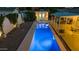 A long, sparkling pool is beautifully illuminated at night, lined with an outdoor lounge and covered sitting area at 421 N Evergreen St, Chandler, AZ 85225