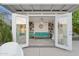 Bright studio with open doors, offering a glimpse of a turquoise couch, bookshelves, and view of outdoor patio at 421 N Evergreen St, Chandler, AZ 85225