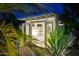 Backyard studio with glass doors featuring desk and bookcase; Lush tropical foliage in foreground enhances privacy at 421 N Evergreen St, Chandler, AZ 85225