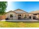 Spacious backyard with lush green lawn, covered patio, and mature trees providing ample shade at 4251 E Sundance Ave, Gilbert, AZ 85297