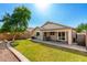 Spacious backyard with lush green lawn, covered patio, and mature trees providing ample shade at 4251 E Sundance Ave, Gilbert, AZ 85297