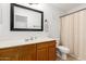 Bathroom features a wooden vanity, shower, toilet, and stylish mirror at 4251 E Sundance Ave, Gilbert, AZ 85297