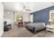 Relaxing bedroom featuring a ceiling fan, blue accent wall, neutral carpet, and natural light at 4251 E Sundance Ave, Gilbert, AZ 85297