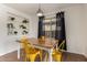 Bright dining area featuring a wooden table, yellow chairs, built-in shelving, and natural light from the window at 4251 E Sundance Ave, Gilbert, AZ 85297