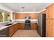 Spacious kitchen with stainless steel appliances, wood cabinets, stone countertops, and wood-look tile flooring at 4251 E Sundance Ave, Gilbert, AZ 85297