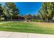 Tennis courts with green grass and trees, offering a serene recreational setting for residents to enjoy friendly matches at 4251 E Sundance Ave, Gilbert, AZ 85297