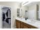 Bright bathroom boasts double sinks, wooden cabinets, and a walk-in closet at 42711 W Darter Dr, Maricopa, AZ 85138