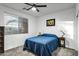Cozy bedroom with a large window, ceiling fan, and a comfortable blue bedspread at 42711 W Darter Dr, Maricopa, AZ 85138