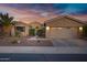 Charming single-story home featuring a two-car garage, desert landscaping, and a beautiful sunset sky at 42711 W Darter Dr, Maricopa, AZ 85138