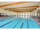 Spacious indoor pool with marked lanes and ample seating, perfect for year-round swimming at 42711 W Darter Dr, Maricopa, AZ 85138