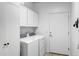Well-equipped laundry room with modern washer, dryer, and ample cabinet storage at 42711 W Darter Dr, Maricopa, AZ 85138