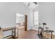 Bright bedroom boasts hardwood floors, arched window with built-in seating, and barn door to the living room at 4301 E Abraham Ln, Phoenix, AZ 85050