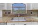 Close up of the kitchen sink, showcasing the granite countertops, backsplash, and window at 4301 E Abraham Ln, Phoenix, AZ 85050