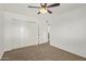 Bedroom featuring plush carpet, ceiling fan, closet, and access to bathroom at 4629 S Mill Ave, Tempe, AZ 85282