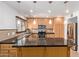 An open kitchen featuring black countertops, wood cabinets, stainless steel appliances, and a kitchen island at 4629 S Mill Ave, Tempe, AZ 85282