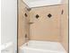 Close-up of bathtub and shower with beige tile featuring dark diamonds at 4629 S Mill Ave, Tempe, AZ 85282