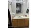 Bathroom with a wood vanity, large mirror, and neutral decor at 4743 W Alice Ave, Glendale, AZ 85302