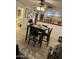 Dining area with black wooden table, tile flooring and access to the kitchen at 4743 W Alice Ave, Glendale, AZ 85302