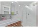 Bright, modern bathroom features a white sink, wooden drawers, walk-in shower, and light gray and white tiling at 5210 W Jupiter N Way, Chandler, AZ 85226
