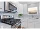 Modern kitchen with stainless steel appliances, white cabinets, and tile backsplash at 5210 W Jupiter N Way, Chandler, AZ 85226