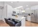 Modern kitchen with white cabinets, stainless steel appliances, and island with chairs at 5210 W Jupiter N Way, Chandler, AZ 85226