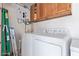 Laundry room features washer, dryer, tankless water heater, overhead cabinets, and a ladder on the side at 5210 W Jupiter N Way, Chandler, AZ 85226