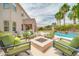 Relaxing backyard featuring a fire pit, lounge chairs, and sparkling pool with palm trees at 5542 W Big Oak St, Phoenix, AZ 85083