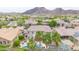 Aerial view of a backyard showcasing a pool, lush palm trees, green grass, and mountain views at 5542 W Big Oak St, Phoenix, AZ 85083