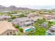 Aerial view of desert home with a luxurious pool, palm trees, covered patio, and mountain views at 5542 W Big Oak St, Phoenix, AZ 85083