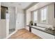 This airy bathroom features a glass-enclosed shower and soaking tub under a large window at 5542 W Big Oak St, Phoenix, AZ 85083