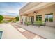 Inviting covered patio with comfortable seating, ceiling fan, and a tranquil view of the landscaped backyard at 5542 W Big Oak St, Phoenix, AZ 85083