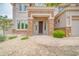 Inviting front entryway with a dark wood door, stone accents, and desert landscaping at 5542 W Big Oak St, Phoenix, AZ 85083