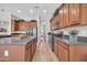 Well-lit kitchen boasts wood cabinets, stainless steel appliances, large center island, and convenient access to other living areas at 5542 W Big Oak St, Phoenix, AZ 85083