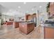 Large kitchen with wood cabinetry, double islands, and access to the living room and dining area at 5542 W Big Oak St, Phoenix, AZ 85083