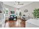 Bright home office featuring hardwood floors, a ceiling fan, a comfortable sofa, and a modern, adjustable work desk at 5542 W Big Oak St, Phoenix, AZ 85083