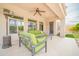 Relaxing covered patio with plush seating, a ceiling fan, and views of the manicured backyard at 5542 W Big Oak St, Phoenix, AZ 85083