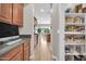 Walk-in pantry with white shelving provides organized storage; the kitchen features gray counters and wood cabinets at 5542 W Big Oak St, Phoenix, AZ 85083