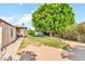 Inviting backyard with a large shade tree, a covered patio, and plenty of space at 6055 E Hannibal St, Mesa, AZ 85205