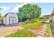 Great backyard featuring a storage shed, a large shade tree, and manicured landscaping at 6055 E Hannibal St, Mesa, AZ 85205
