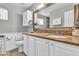 Elegant bathroom featuring double sinks with granite countertop, white cabinets, and large mirror at 6055 E Hannibal St, Mesa, AZ 85205