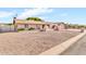 Single-story home featuring desert landscaping and a charming, light pink exterior paint at 6055 E Hannibal St, Mesa, AZ 85205