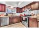 Well-equipped kitchen with stainless steel appliances, neutral countertops, and dark wood cabinets at 6055 E Hannibal St, Mesa, AZ 85205