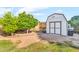 Backyard shed with neutral colors next to a large tree, perfect for storage at 6055 E Hannibal St, Mesa, AZ 85205