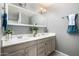 Bright bathroom featuring a double sink vanity with a large mirror and modern lighting at 611 E Colgate Dr, Tempe, AZ 85283