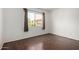 Bright bedroom features hardwood floors and a large window offering pleasant community views at 611 E Colgate Dr, Tempe, AZ 85283