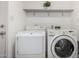 Well-equipped laundry room features a washer, dryer, and a shelf for supplies at 611 E Colgate Dr, Tempe, AZ 85283